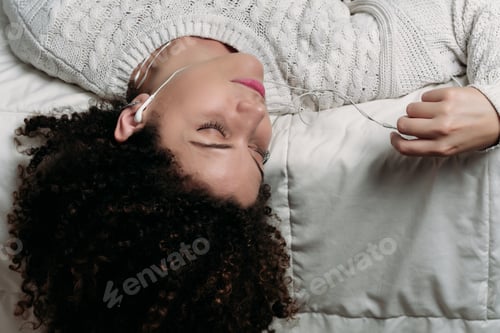 Preview: Young Beautiful Woman Lying On Bed And Listening To Music With Headphones. Smiling Woman Enjoying