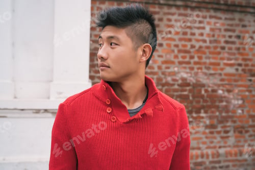 Preview: Portrait Of Young Handsome Asian Man Wearing Casual Clothes Against The Brick Wall In The Street