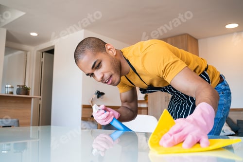 Preview: Close Up Of Young Latin Man Cleaning Stains Off The Table At Home. Housekeeping And Cleaning