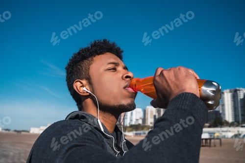 Preview: Portrait Of An Athletic Man Drinking Something After Training At The Beach. Sport And Health