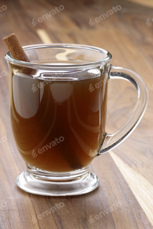 Preview: Warm Beverage with Cinnamon Stick on Wooden Surface
