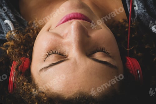 Preview: Portrait Of Attractive Woman Listening To Music While Lying On Sofa In Living Room