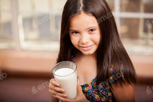 Preview: Portrait Of A Beautiful Little Girl Enjoying A Glass Of Milk And Smiling