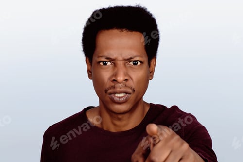 Preview: Portrait Of An Angry Afro American Man Pointing At Camera On Studio. Emotions