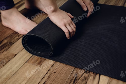 Preview: Close-Up Of Attractive Young Woman Rolling Her Fitness Mat Before Or After Yoga Class At Home