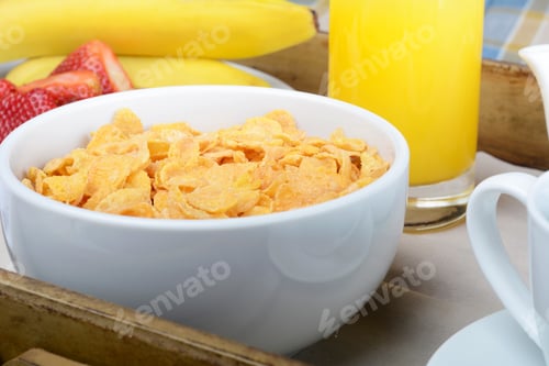Vista previa: Primer plano de la bandeja de desayuno con zumo de naranja, cereales y fruta.