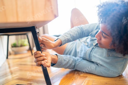 Preview: Portrait Of Young Afro Woman Repairing Furniture With A Screwdriver At Home. Repair And Renovation