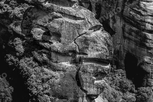 Preview: A Greyscale Of Rocks Covered In Mosses And Trees Under Sunlight
