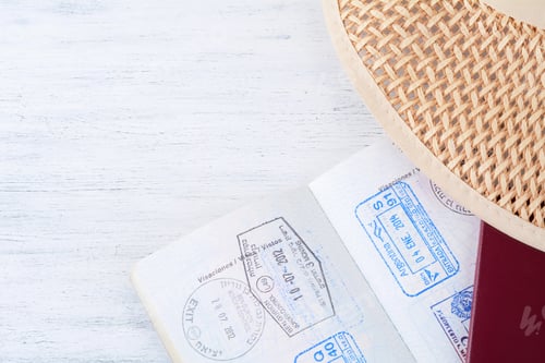 Preview: Close Up Of Open Passport With Visa Stamps And Hat. Travel Concept.