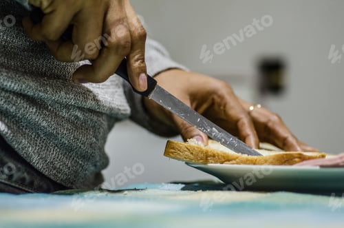 Preview: Female Hands Cutting Wheaten Bread On The Wooden Board