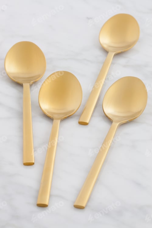 Visualização: Conjunto de colheres douradas estilizado em mármore antigo de Carrara