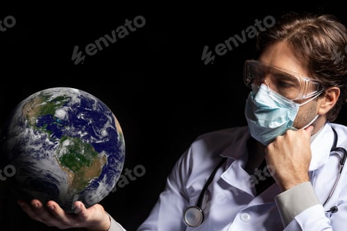 Preview: Male Doctor Wearing A Mask And Goggles With Earth In His Hands, Tired Of Working With Covid-19 On A