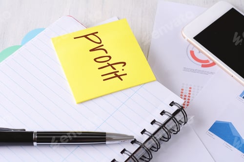Preview: Close Up Of Business Stuff With Technology Devices And Sticky Paper With "Profit" Text. Business