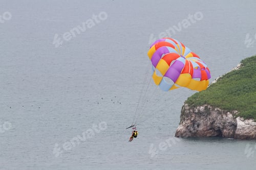 Preview: Close Up Of Two Persons On A Parasailing Boat Ride Over The Ocean Going Over An Island