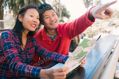 Preview: Portrait Of Happy Asian Traveler Couple Holding A Map And Looking For Directions. Travel And