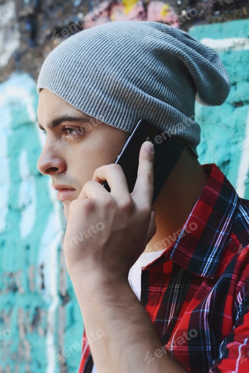 Preview: Portrait Of Young Handsome Man Talking On The Phone Outdoors