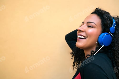 Preview: Portrait Of Young Afro Woman Enjoying And Listening To Music With Blue Headphones. Technology And