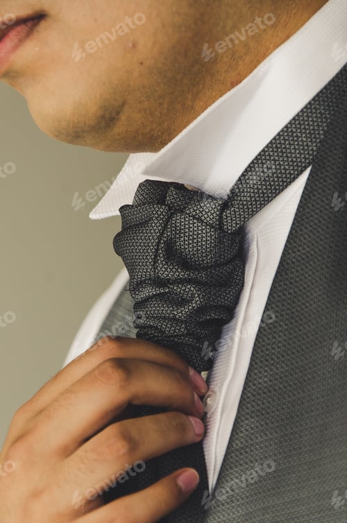 Man Adjusting Gray Neckwear with Suit and White Shirt
