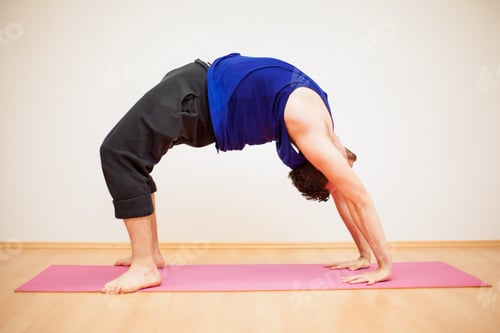 Preview: Portrait Of A Young Man Doing A Backbend Pose In A Yoga Studio Against A White Background