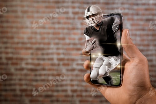 Preview: Football Player With A Black Uniform Playing And Coming Out Of A Full Screen Phone In Front Of A