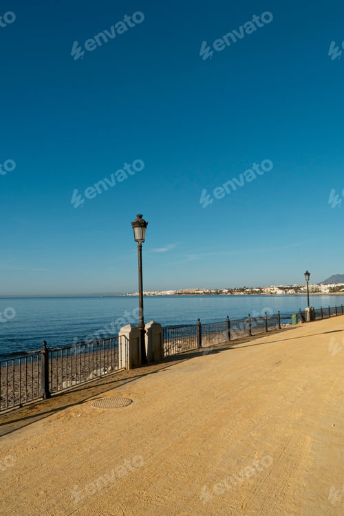 Preview: Landscape On The Boardwalk With Lighthouses And Blue Sea. Marbella, Spain.