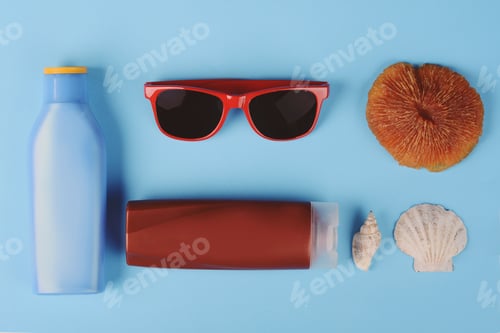 Preview: Top View Of Sunglasses, Shells, Starfish And Sunblock. Summer Concept. Light Blue Background