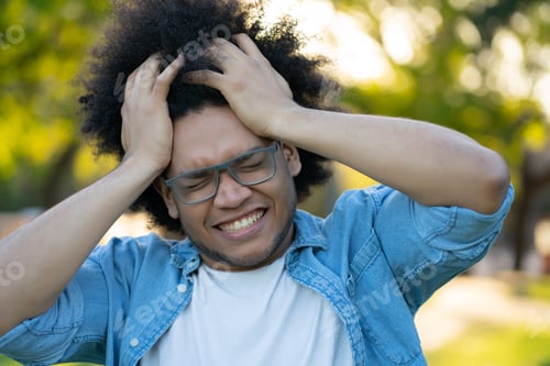 Preview: Young Man Suffering Headache Outdoors.
