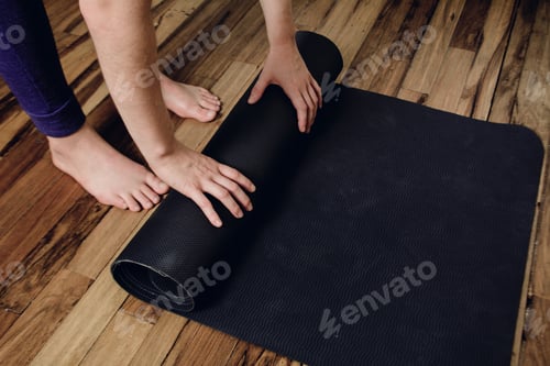 Preview: Close-Up Of Attractive Young Woman Rolling Her Fitness Mat Before Or After Yoga Class At Home