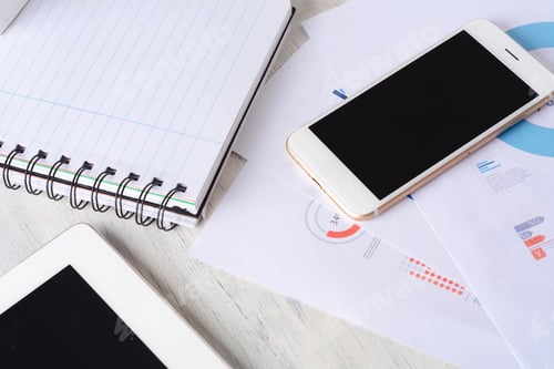 Preview: Close Up Of Phone, Smartphone, Spiral Notepad And Financial Papers With Charts And Numbers