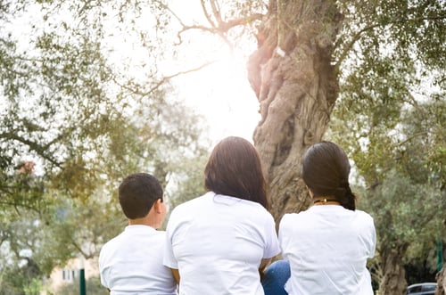 Vista previa: Mom With Children Sitting On Their Backs With The Forest Background.