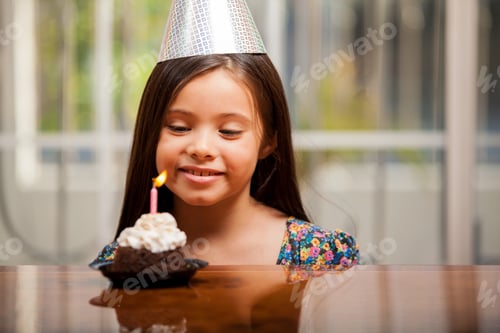 Preview: Beautiful Little Girl On A Party Hat Making A Birthday Wish On Her Birthday