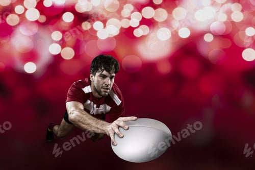 Preview: Rugby Player In A Red Uniform Scoring On A Red Lights Background.