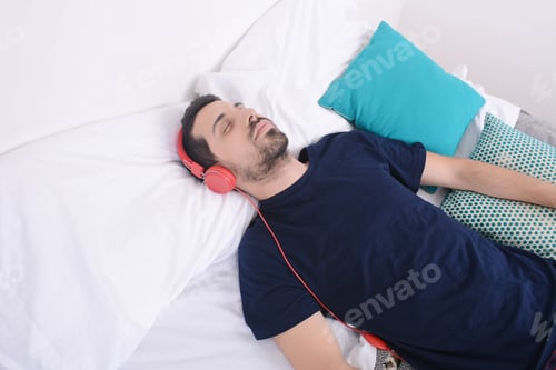 Preview: Attractive Young Man Listening To Music And Relaxed In Bed. Indoors.