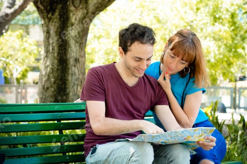 Preview: Young Beautiful Couple Holding Map In Hands And Traveling Together. Tourism Concept. Outdoors.