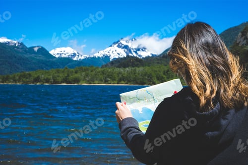 Preview: Woman Looking At A Map With Mountains In The Background. Travel Concept.