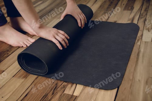 Preview: Close-Up Of Attractive Young Woman Rolling Her Fitness Mat Before Or After Yoga Class At Home