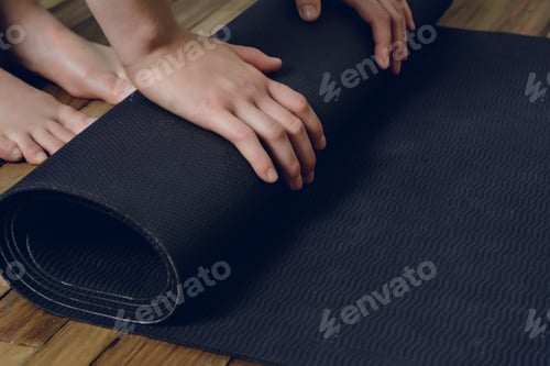 Preview: Close-Up Of Attractive Young Woman Rolling Her Fitness Mat Before Or After Yoga Class At Home