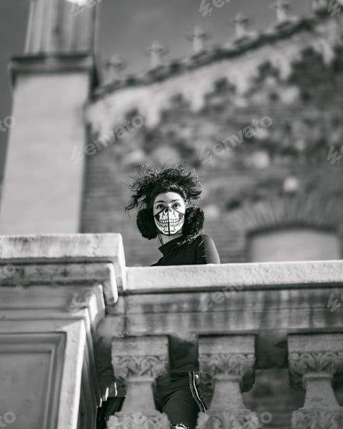 Visualização: A Grayscale Shot Of An Attractive Latina With A Scary Face Mask And Winter Earmuffs Posing At Camera