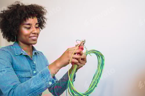 Preview: Portrait Of Young Afro Woman Fixing Electricity Problem With Cables At New Home. Repair And