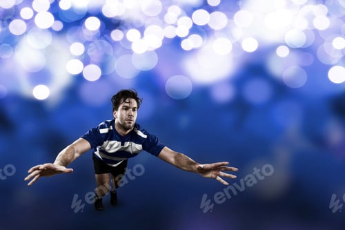 Preview: Rugby Player In A Blue Uniform Giving A Tackle On A Blue Lights Background.