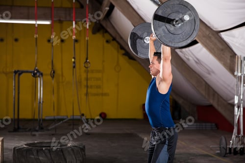 Preview: Profile View Of A Strong Young Man Lifting Some Weights In A Cross-Training Gym