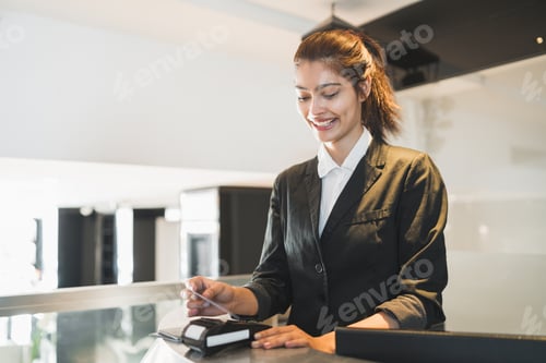 Preview: Portrait Of Receptionist Passing Card And Charging Guest Stay At Reception Front Desk. Travel