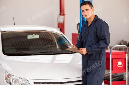 Preview: Handsome Young Man Holding A Checklist In Front Of A Car In An Auto Shop