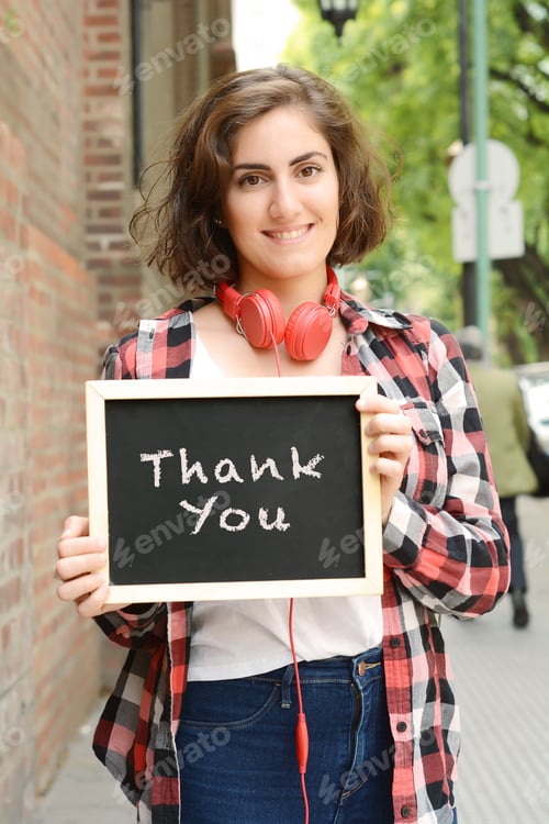 Preview: Young Beautiful Woman Holding Chalkboard With Text "Thank You". Outdoors.