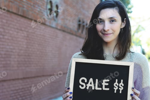Aperçu: Portrait d'une jeune femme latine tenant un tableau noir avec vente de texte. Concept du Black Friday.