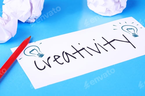 Preview: Paper With "Creativity" Text And Crumpled Paper Balls On Light Blue Background. Brainstorming