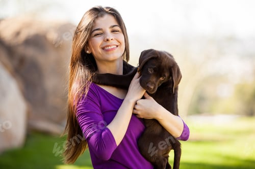 Preview: Pretty Young Brunette Hugging Her Cute Lab Puppy Outdoors And Smiling
