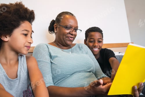 Preview: Portrait Of African American Grandmother Reading A Book To Her Grandchildren At Home. Family