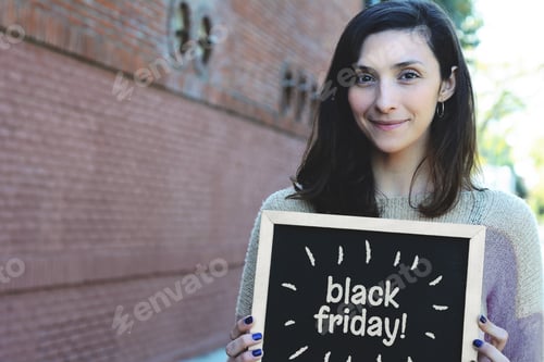 Preview: Portrait Of Young Woman Holding Chalkboard With Text Black Friday. Sale Concept.