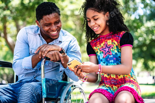 Preview: Man In A Wheelchair Using Smartphone With Her Daughter.